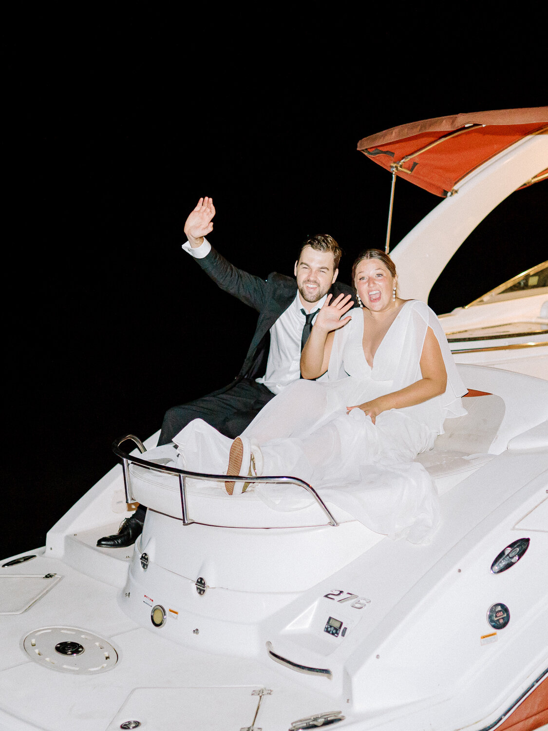 bride and groom leaving on a boat