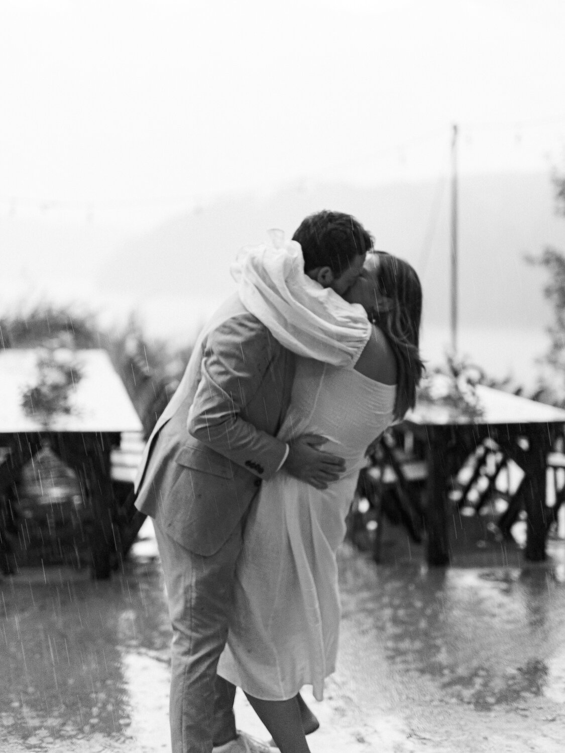 bride and groom kissing in rain